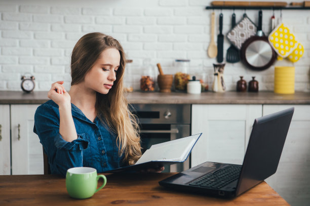 一个怀孕的女孩，一个在家里厨房工作的自由职业者图片下载