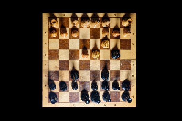 一盘国际象棋从开始到结束，将白将黑。四骑士开局，开局e2 - e4，俯视图为黑色背景图片下载