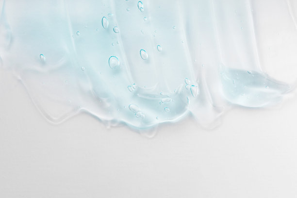 洗手液，卫生液凝胶。清晰的护肤品涂抹特写。奶油凝胶蓝色透明化妆品样品与泡沫隔离在白色背景。图片下载