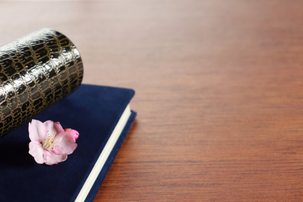 桌上放着一张毕业证书和一本毕业相册。图片下载