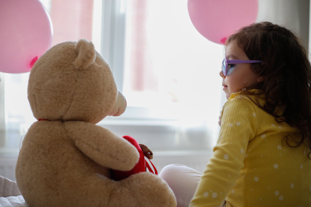 小女孩坐在床上与泰迪熊照片系列库存照片图片下载