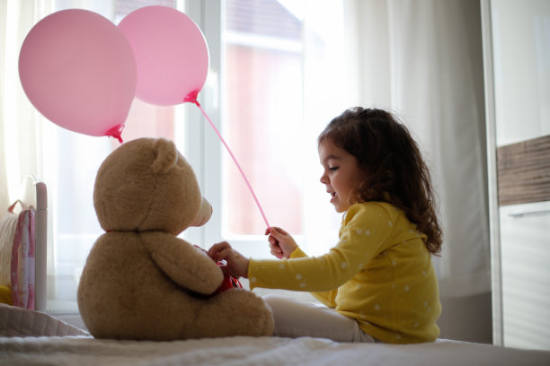 小女孩坐在床上与泰迪熊照片系列库存照片图片下载