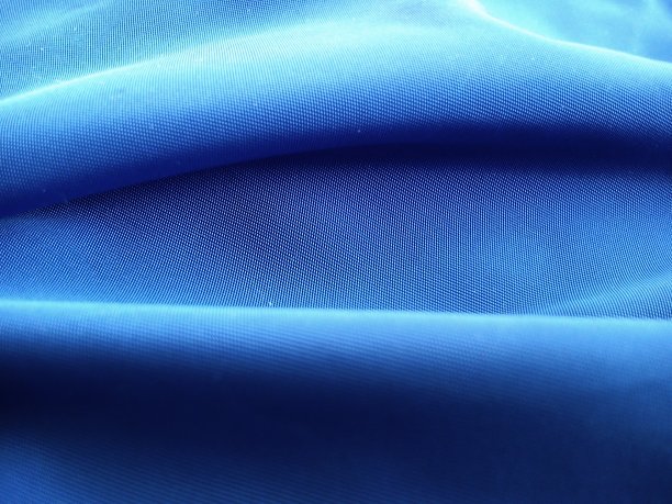近距离的蓝色织物，呈水平波浪状。蓝色阴影中的抽象图像。图片下载