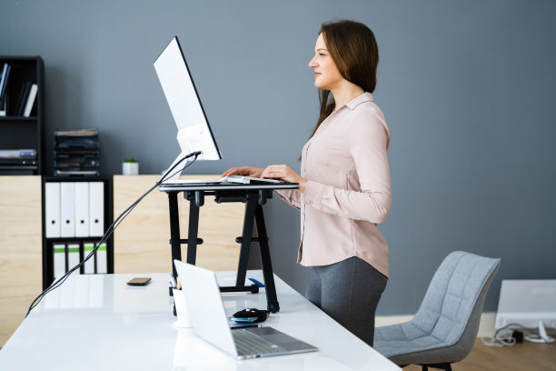 可调节高度的办公桌站在办公室图片下载