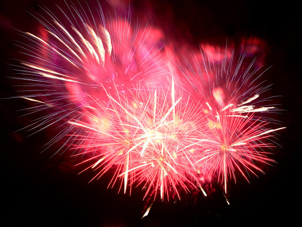 红色的烟花在点燃的烟雾和黑色的天空背景图片下载