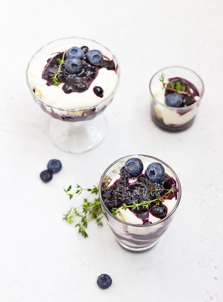 提拉米苏。自制的玻璃杯甜点，用蓝莓、奶油和手指饼干装饰蓝莓和百里香。光石背景。图片下载