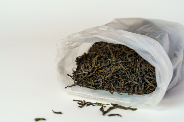 干红茶茶叶在塑料袋白色的背景。图片下载