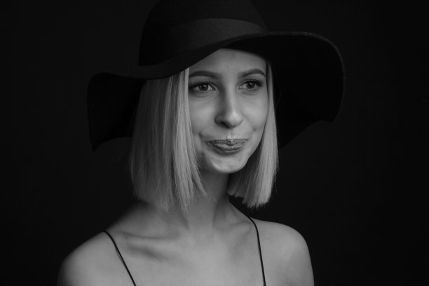 黑色和白色肖像金发在黑色背景的帽子和背心与细带图片下载