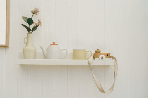 木制的相机玩具与可爱的白色茶壶和古董花瓶在白色架子美丽的背景。图片下载