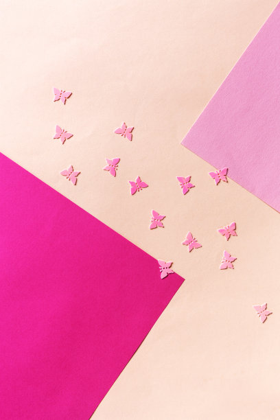 近距离的照片粉红色蝴蝶在彩色的粉红色背景上闪闪发光的纸屑。俯视图，春天，复活节和各种节日和事件的概念图片下载