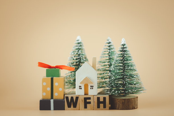 微型的家放置在木制积木与礼物盒和圣诞树在黄色的背景图片下载