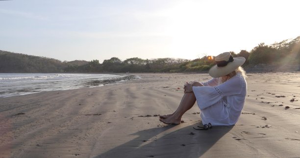 女人在日出的沙滩上放松图片下载