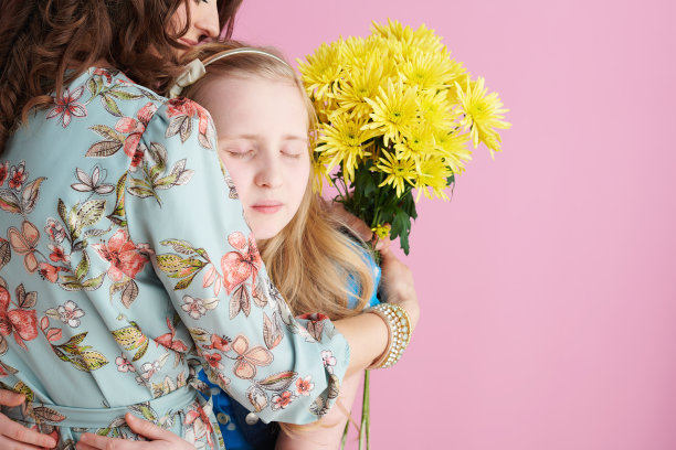 多愁善感的时尚母亲和孩子拥抱在粉红色图片下载