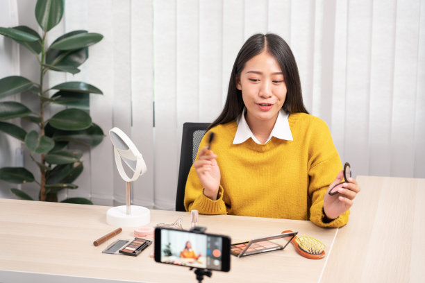 亚洲女性在家通过互联网向社交网络展示美容化妆品并直播视频，以美容博客为理念图片下载