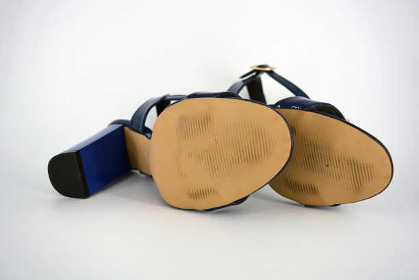 美丽和明亮的女性蓝色漆凉鞋，由真皮制成，白色背景下的金色鞋垫。图片下载