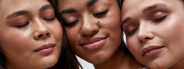 三名不同的女性的脸部裁剪肖像，在灯光背景下合上眼睛摆姿势图片下载