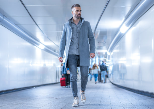 街头风格，大都会的照片，一个年轻的白人黑发女子穿着灰色的美国夹克在地铁隧道图片下载