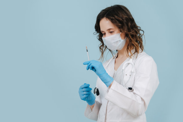 无表情的护士从注射器中挤出空气注射疫苗。在蓝色的图片下载