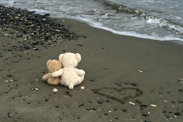 沙滩上有两只泰迪熊和一颗心图片下载