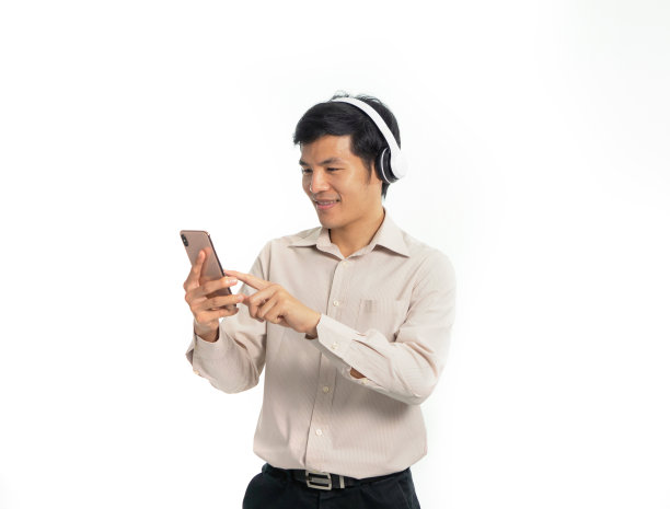 年轻的亚洲商人使用智能手机听音乐通过无线蓝牙耳机，技术设备。舞蹈放松孤立在白色背景图片下载