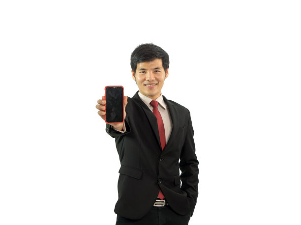 一个快乐的年轻亚洲商人在白色背景下使用手机。技术设备。图片下载