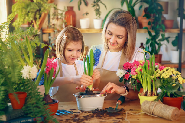 可爱的小女孩帮助妈妈照料植物图片下载