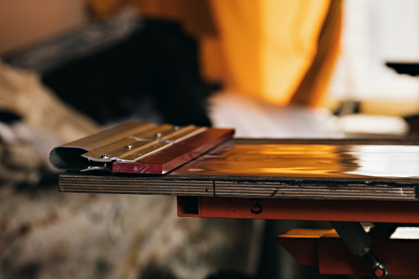 选择性聚焦照片的橡皮刮在木制架子上的印刷筛选装置。绢印生产。在设计工作室用丝印法在t恤上印刷图像图片下载