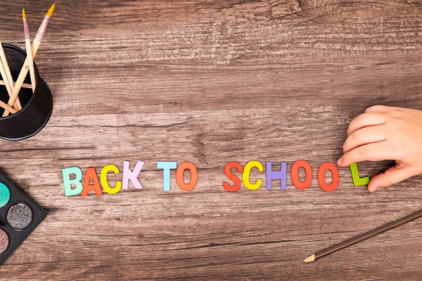 俯视图平躺男孩手打字母表回学校在木制的背景与复制空间图片下载