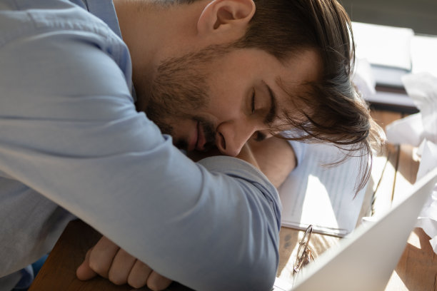 近距离观看疲惫的商人在工作场所睡觉图片下载