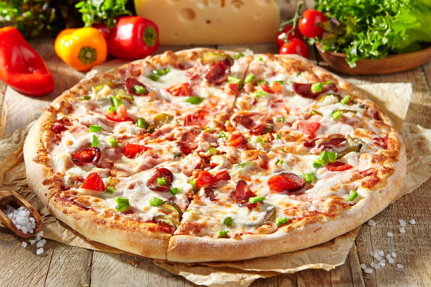 披萨餐厅菜单-羊皮纸上的肉披萨，上面有肉、热香肠和意大利辣香肠片。摆着披萨配料的木桌。阳光带着刺眼的阴影。质朴、自然的食物。图片下载