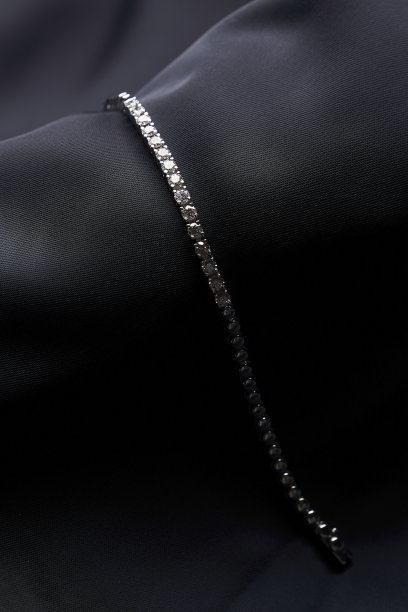 铂金手镯与钻石在黑色丝绸背景图片下载