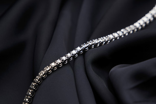 铂金手镯与钻石在黑色丝绸背景图片下载
