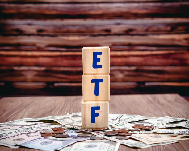 在一张桌子上，用蓝色字母拼成的“ETF”(交易所交易基金)字样的木方。投资理念的照片。图片下载