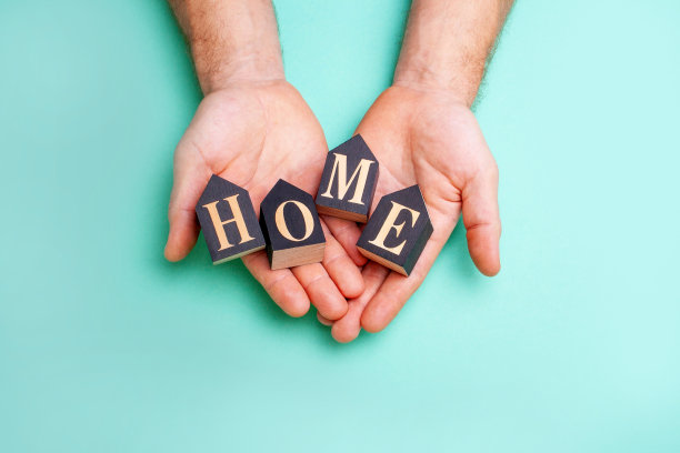 男手捧字母带题字回家。舒适、家庭、房子的概念图片下载
