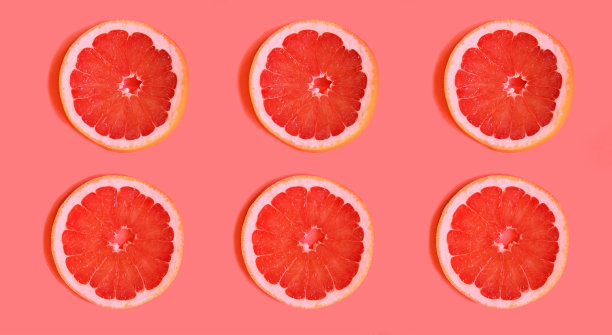 美味的葡萄柚片平躺在明亮的背景上。水果切片放在一个明亮的背景上，对比鲜明的背景吸引注意力。一个烹饪博客的广告。明亮的多汁的颜色图片下载