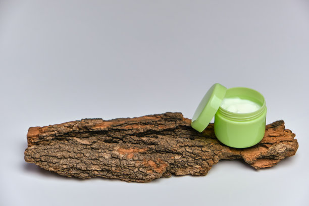 面霜在绿色罐子树皮，白色背景。图片下载