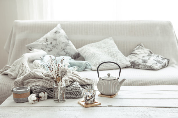 客厅的桌子上放着一个茶壶，茶壶上装饰着hygge的细节。图片下载