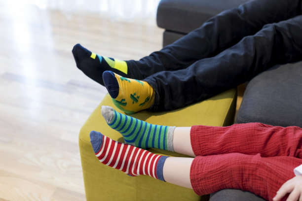 唐氏综合症意识概念。男人和男孩穿不同的袜子。图片下载