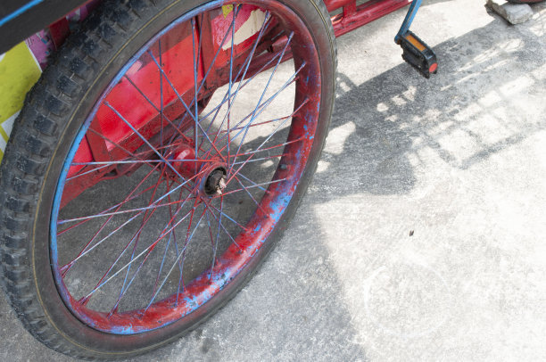 自行车的轮子被漆成红色，放在水泥地板上。图片下载