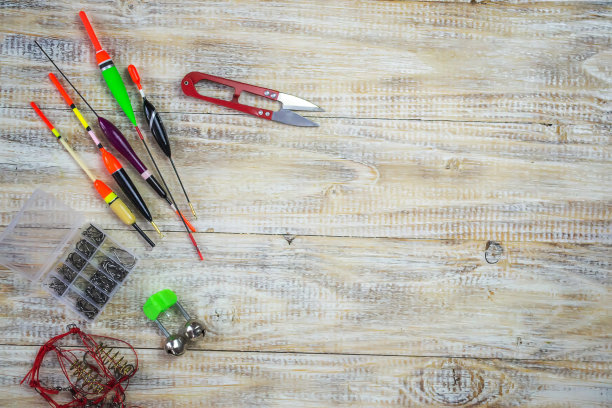 钓鱼用具垂钓者-游泳者，垂直下落和木制背景上的工具。有选择性的重点图片下载