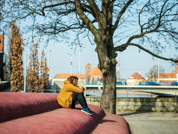 一个悲伤的年轻人独自坐在城市里图片下载