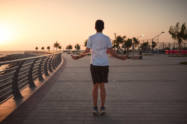 男人在海边日落时分跳绳图片下载