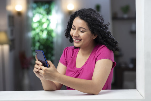 一个年轻女子站在窗户和阳台附近的照片:库存照片图片下载