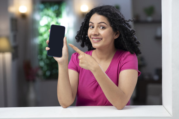 一个年轻女子站在窗户和阳台附近的照片:库存照片图片下载