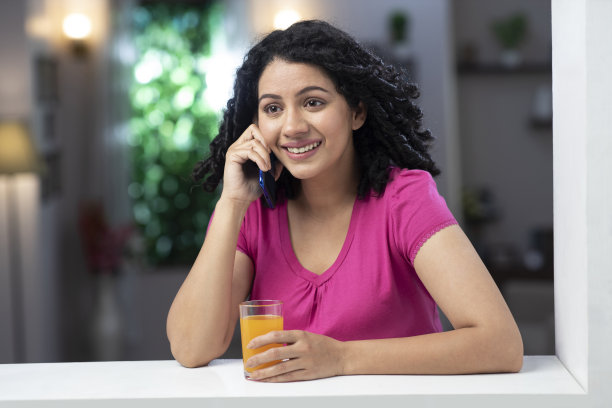 一个年轻女子站在窗户和阳台附近的照片:库存照片图片下载