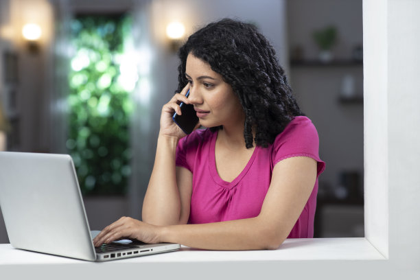 一个年轻女子站在窗户和阳台附近的照片:库存照片图片下载