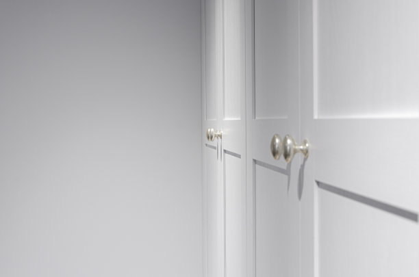 家具配件。金属银色的门把手与鲜明的阴影在白色立面上图片下载