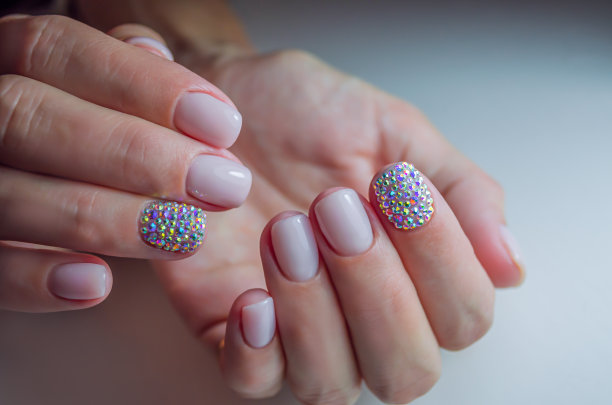 女人的手与精致的美甲和人造钻石。假日、婚礼或订婚的设计构思。图片下载