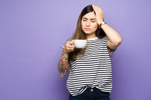 头疼的漂亮女人喝着咖啡图片下载