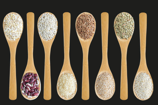 谷物在一个木勺排成一行石墨背景特写。图片下载